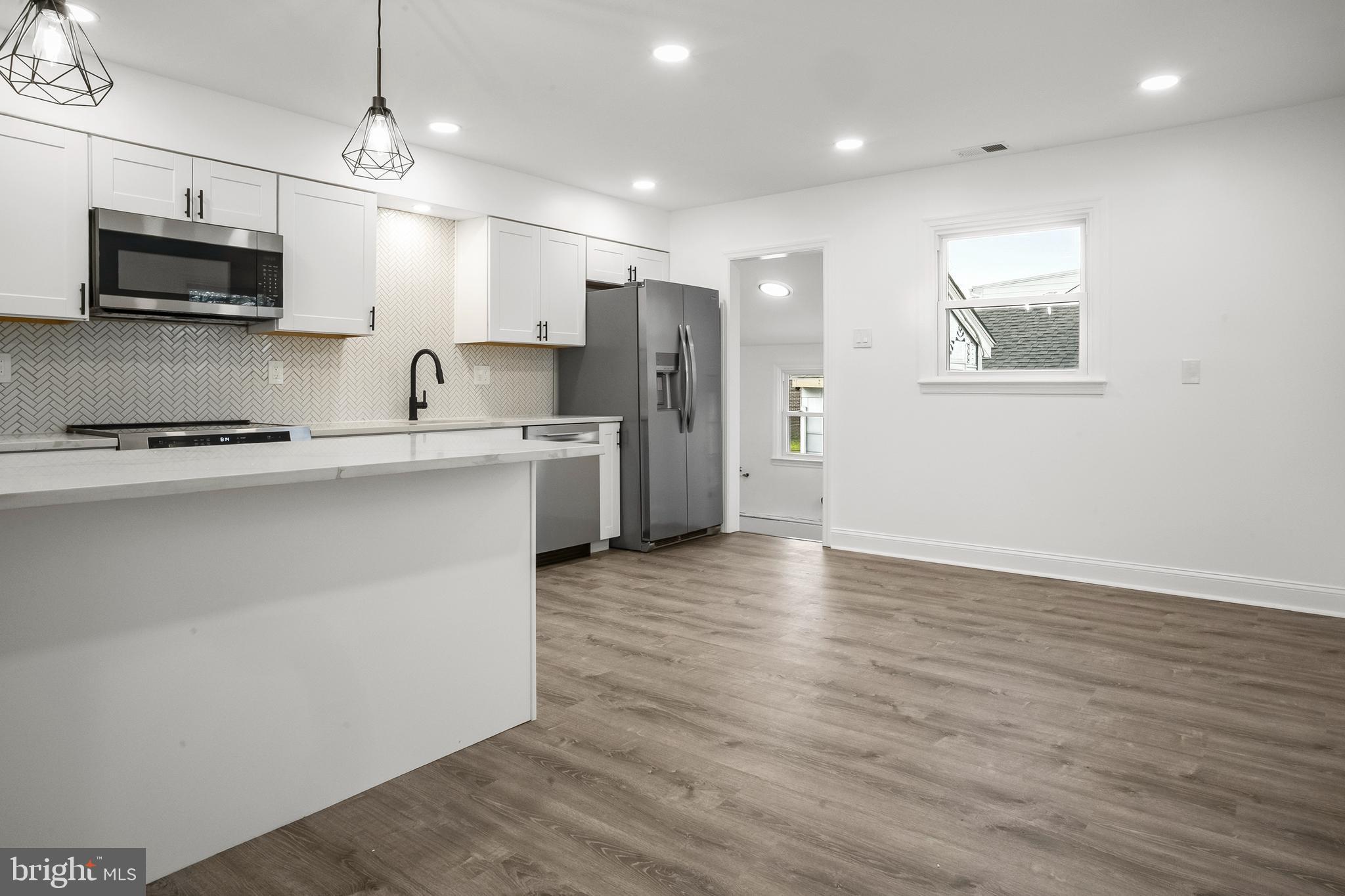 601 Evesham Avenue West Magnolia, NJ 08049 - Photo 8 of 20 a kitchen with stainless steel appliances granite countertop a sink a stove a refrigerator cabinets and wooden floor