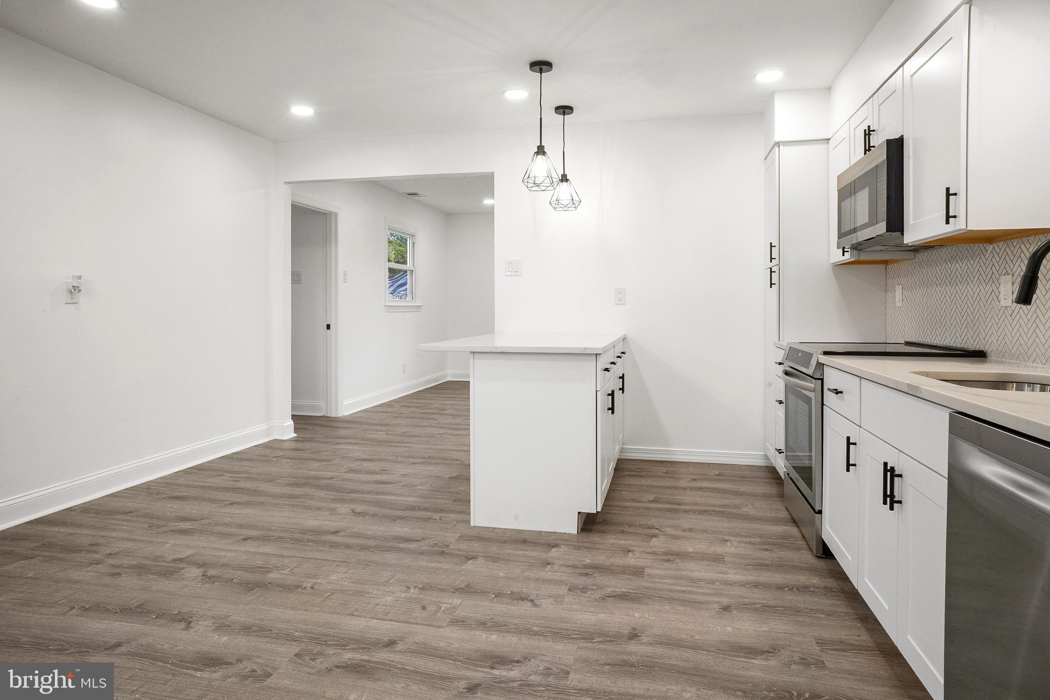 601 Evesham Avenue West Magnolia, NJ 08049 - Photo 9 of 20 a kitchen with kitchen island white cabinets and refrigerator