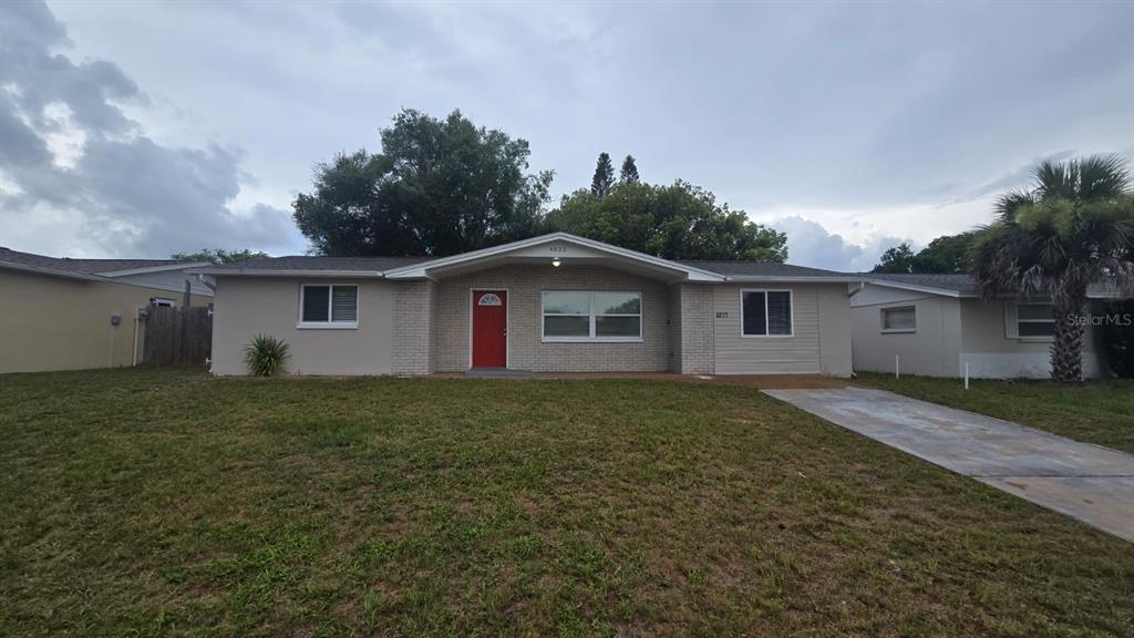 4833 Fleetwood Street New Port Richey, FL 34653 - Photo 1 of 1 a view of a house with a yard and a garden