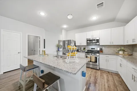 a kitchen with granite countertop a sink and cabinets