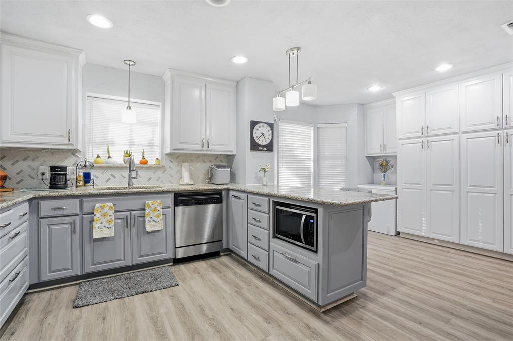685 Cardinal Ridge Road Burleson, TX 76028 - Photo 11 of 40 a kitchen with stainless steel appliances granite countertop a sink a stove a refrigerator and white cabinets
