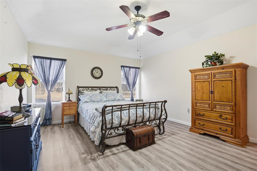 685 Cardinal Ridge Road Burleson, TX 76028 - Photo 20 of 40 a spacious bedroom with a bed and a chandelier