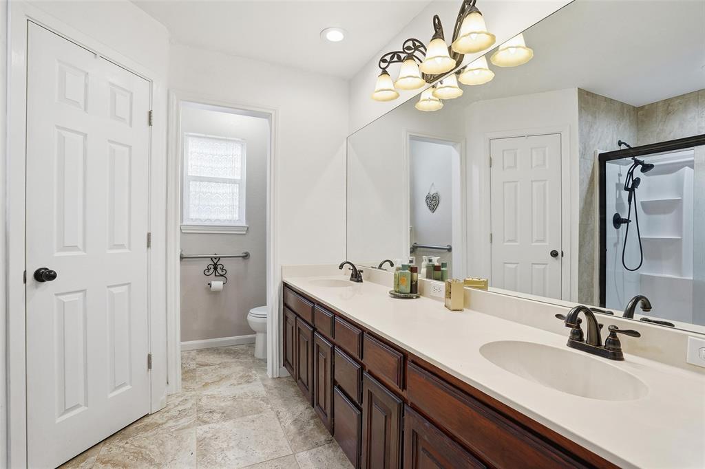 685 Cardinal Ridge Road Burleson, TX 76028 - Photo 22 of 40 a bathroom with double vanity sinks a vanity a lamp and a mirror