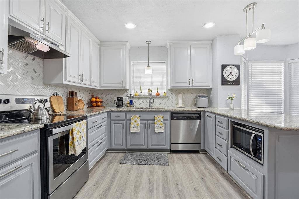 685 Cardinal Ridge Road Burleson, TX 76028 - Photo 3 of 40 a kitchen with stainless steel appliances granite countertop a sink a stove a refrigerator and cabinets with wooden floor