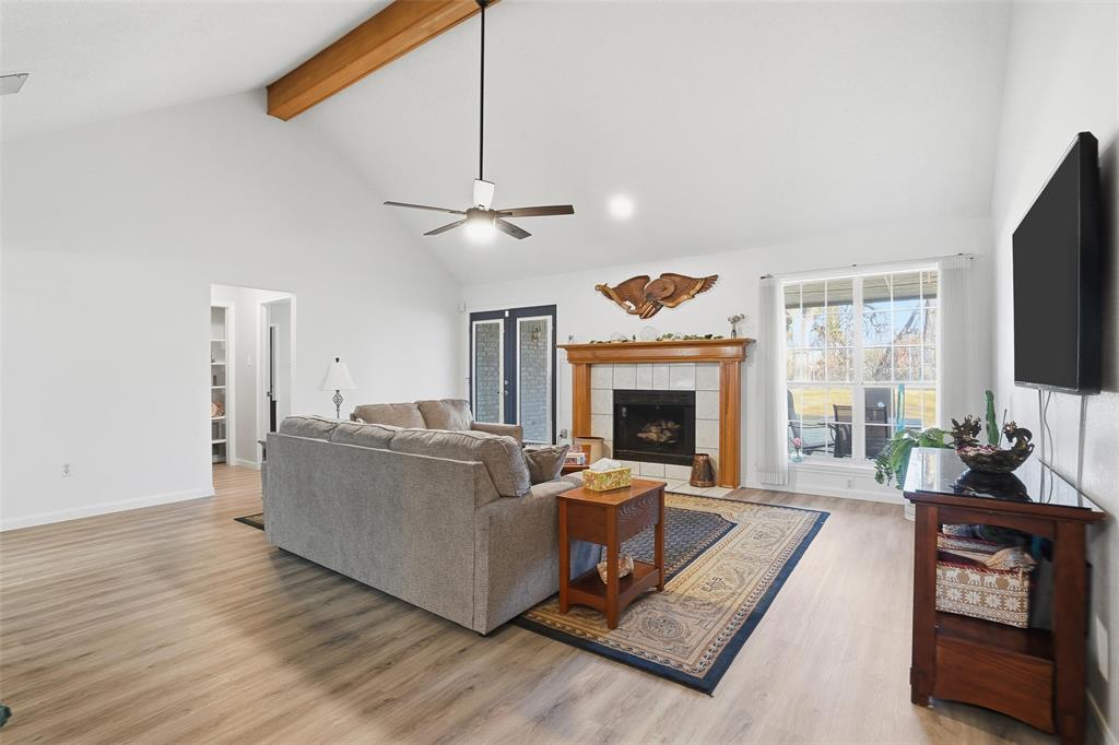 685 Cardinal Ridge Road Burleson, TX 76028 - Photo 4 of 40 a living room with furniture a fireplace and a flat screen tv
