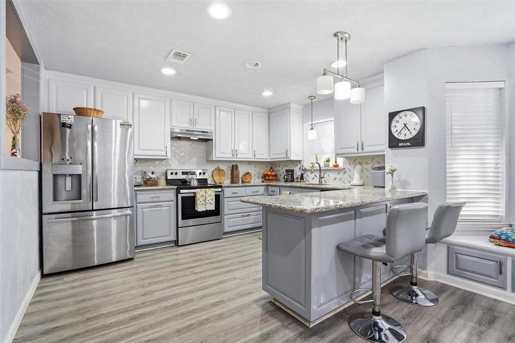 685 Cardinal Ridge Road Burleson, TX 76028 - Photo 8 of 40 a kitchen with granite countertop a refrigerator a stove a sink dishwasher a dining table and chairs with wooden floor