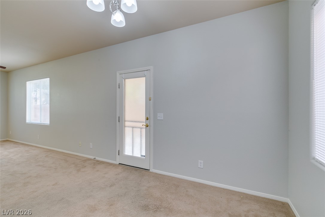 8937 Caledon Ridge Court Las Vegas, NV 89149 - Photo 16 of 43 A spacious room offers comfortable carpet flooring and multiple windows for natural light.