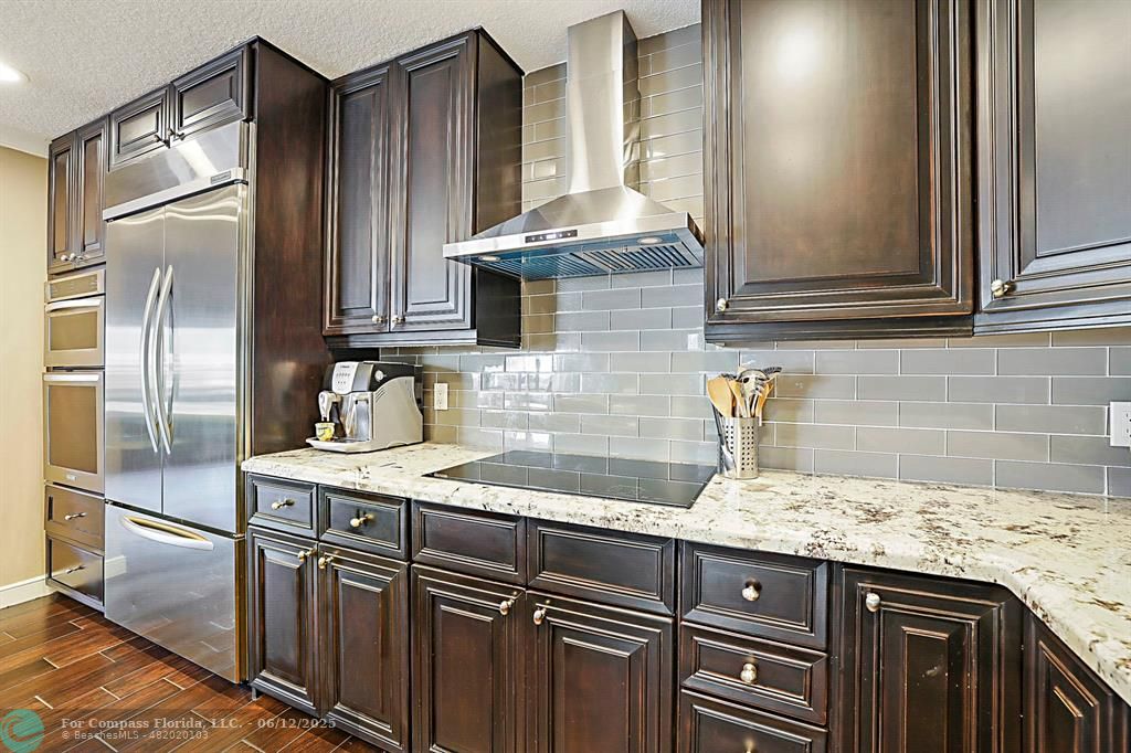 2743 Northeast 28th Court, Unit 3 Lighthouse Point, FL 33064 - Photo 14 of 56 a kitchen with granite countertop stainless steel appliances a sink and a refrigerator