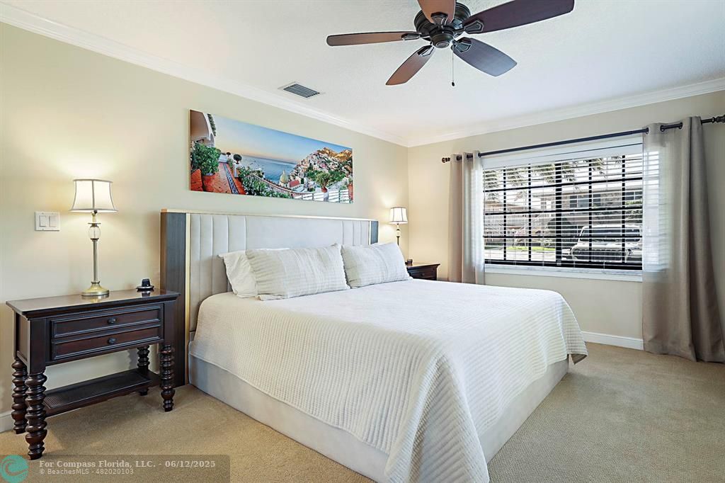 2743 Northeast 28th Court, Unit 3 Lighthouse Point, FL 33064 - Photo 22 of 56 a bedroom with a bed and a chandelier