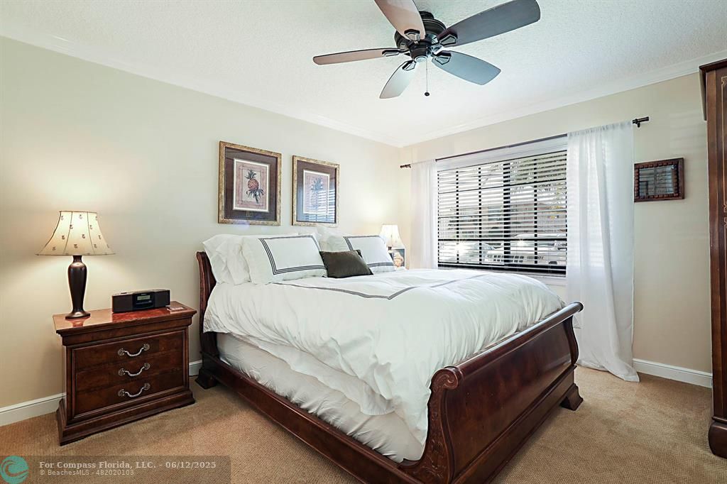 2743 Northeast 28th Court, Unit 3 Lighthouse Point, FL 33064 - Photo 27 of 56 a spacious bedroom with a bed and a ceiling fan
