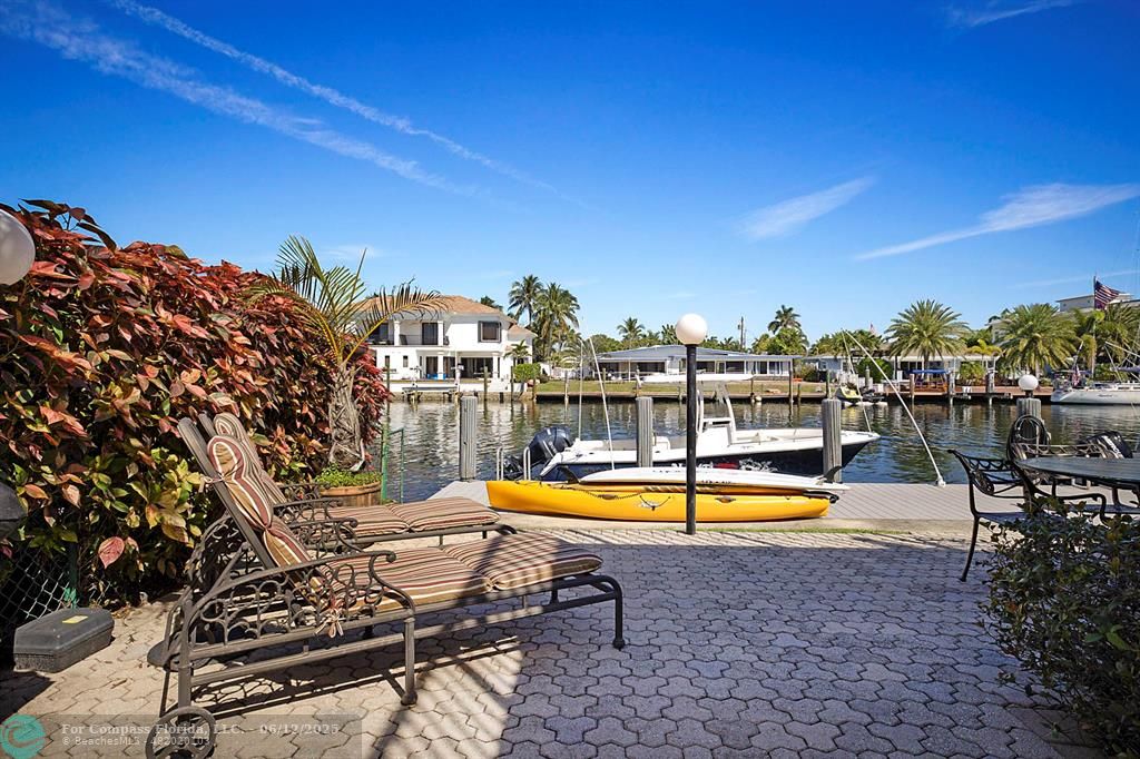 2743 Northeast 28th Court, Unit 3 Lighthouse Point, FL 33064 - Photo 36 of 56 a view of a swimming pool with a table and chairs