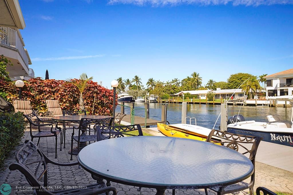 2743 Northeast 28th Court, Unit 3 Lighthouse Point, FL 33064 - Photo 38 of 56 a view of a swimming pool with a table and chairs