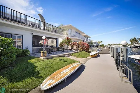 an aerial view of ocean and residential houses with outdoor space