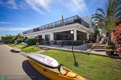 an aerial view of ocean and residential houses with outdoor space