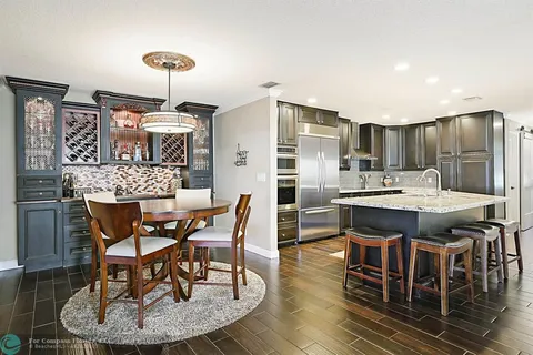 a kitchen with stainless steel appliances granite countertop a stove top oven a sink dishwasher and wooden cabinets