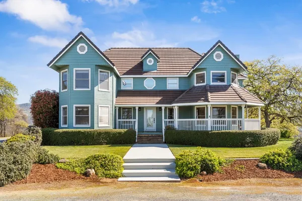 a front view of a house with a yard and plants