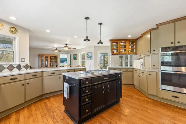 a kitchen with kitchen island granite countertop wooden floors and white cabinets