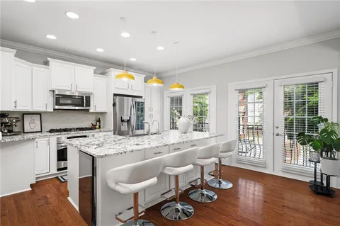 a large kitchen with kitchen island a large counter top space a sink stainless steel appliances and cabinets
