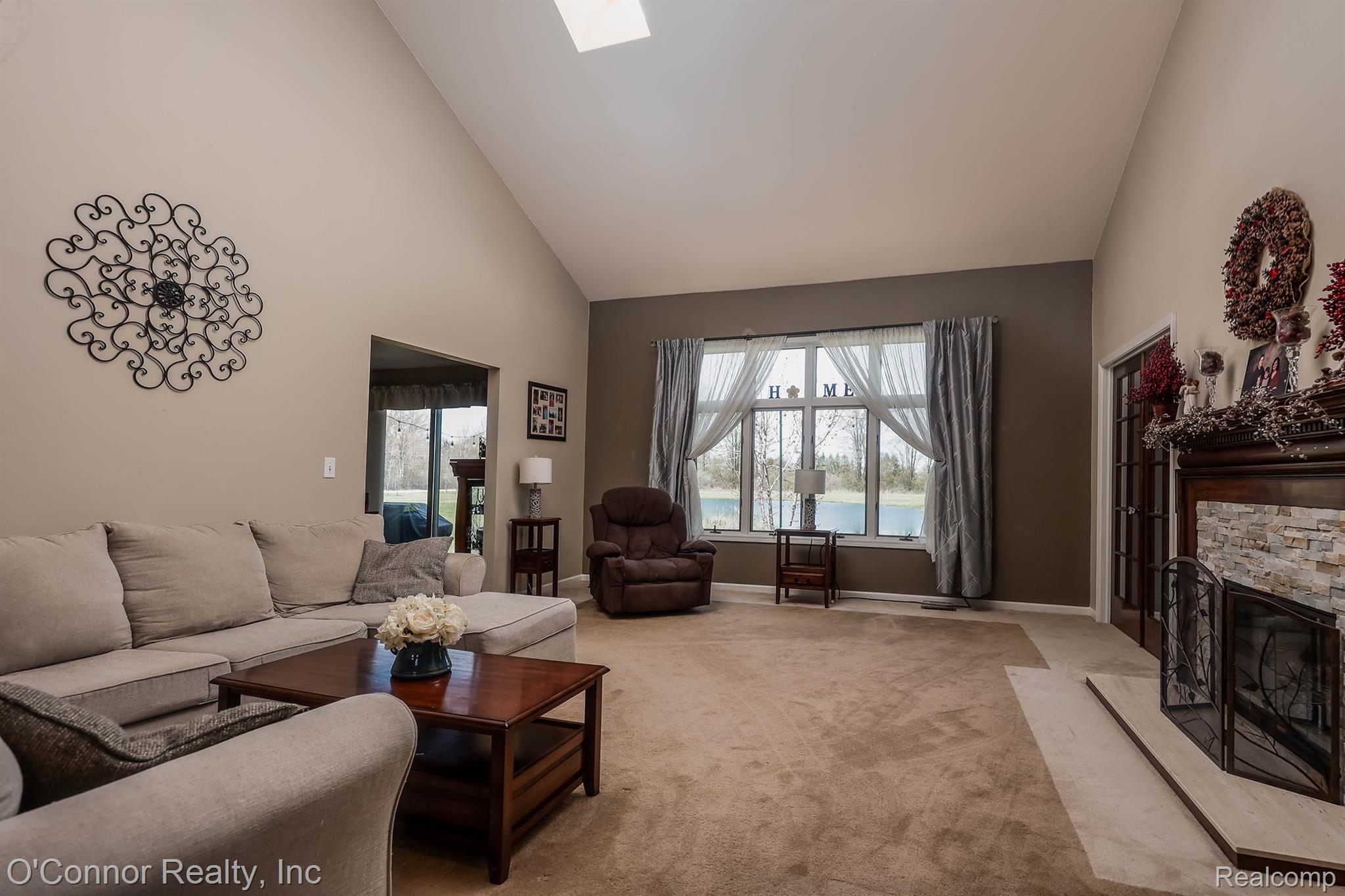 7978 Frith Road Columbus, MI 48063 - Photo 4 of 56 Living area with lofted ceiling, carpet floors, a skylight, and a fireplace
