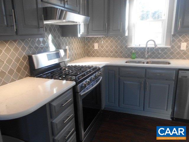 3232 Briery Road Keysville, VA 23947 - Photo 15 of 32 a kitchen with granite countertop a stove a sink dishwasher and cabinets with wooden floor