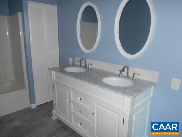 3232 Briery Road Keysville, VA 23947 - Photo 24 of 32 a bathroom with a double vanity sink and a mirror