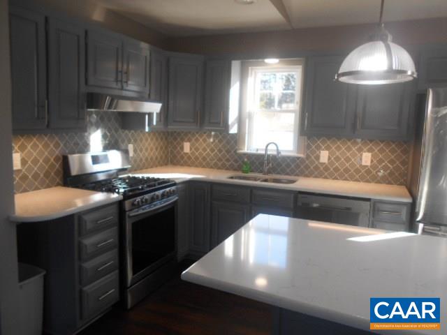 3232 Briery Road Keysville, VA 23947 - Photo 9 of 32 a kitchen with granite countertop a sink stainless steel appliances a counter space and a window
