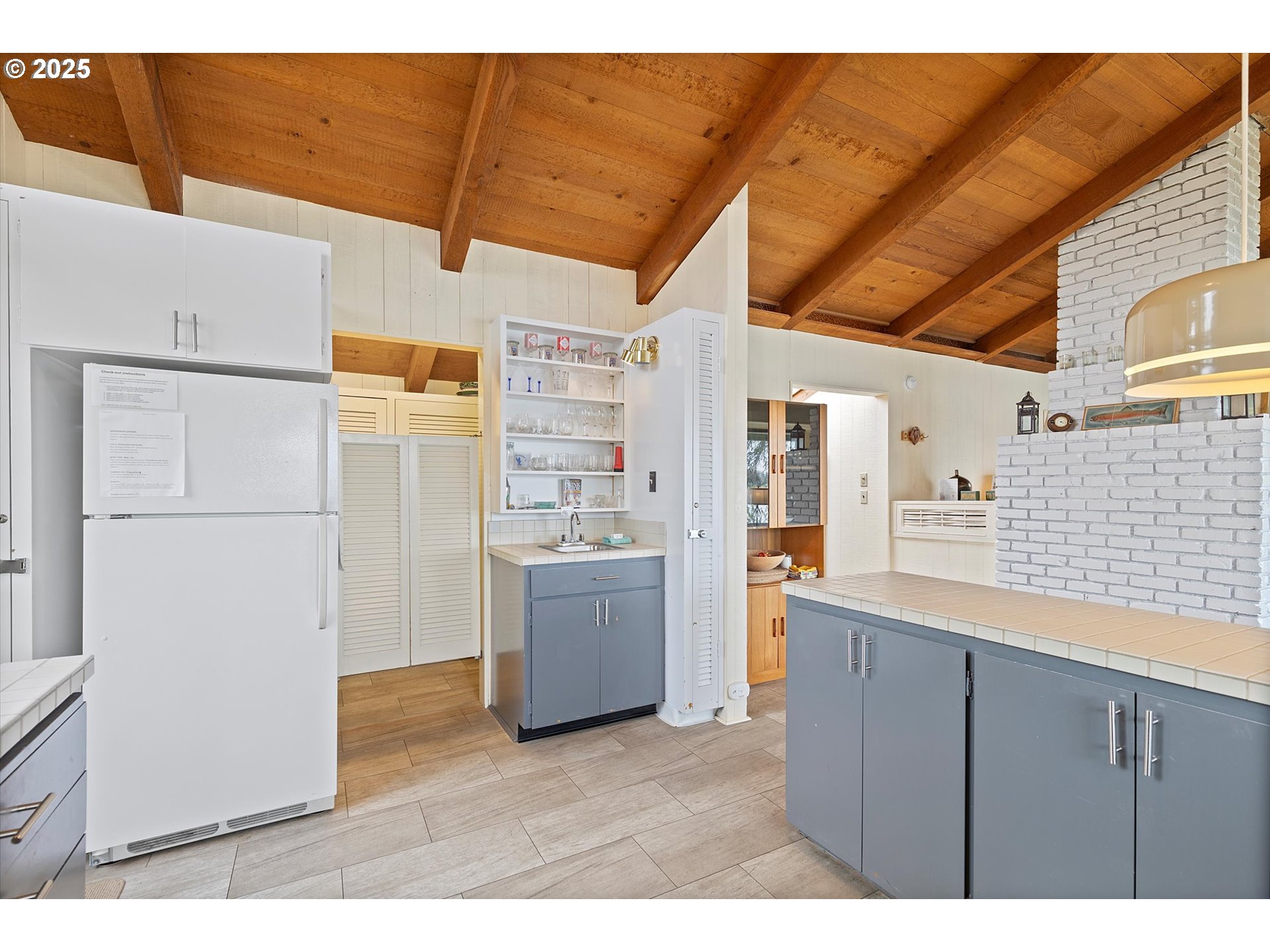 2871 Northeast East Devils Lake Road Otis, OR 97368 - Photo 11 of 48 a kitchen with refrigerator and cabinets