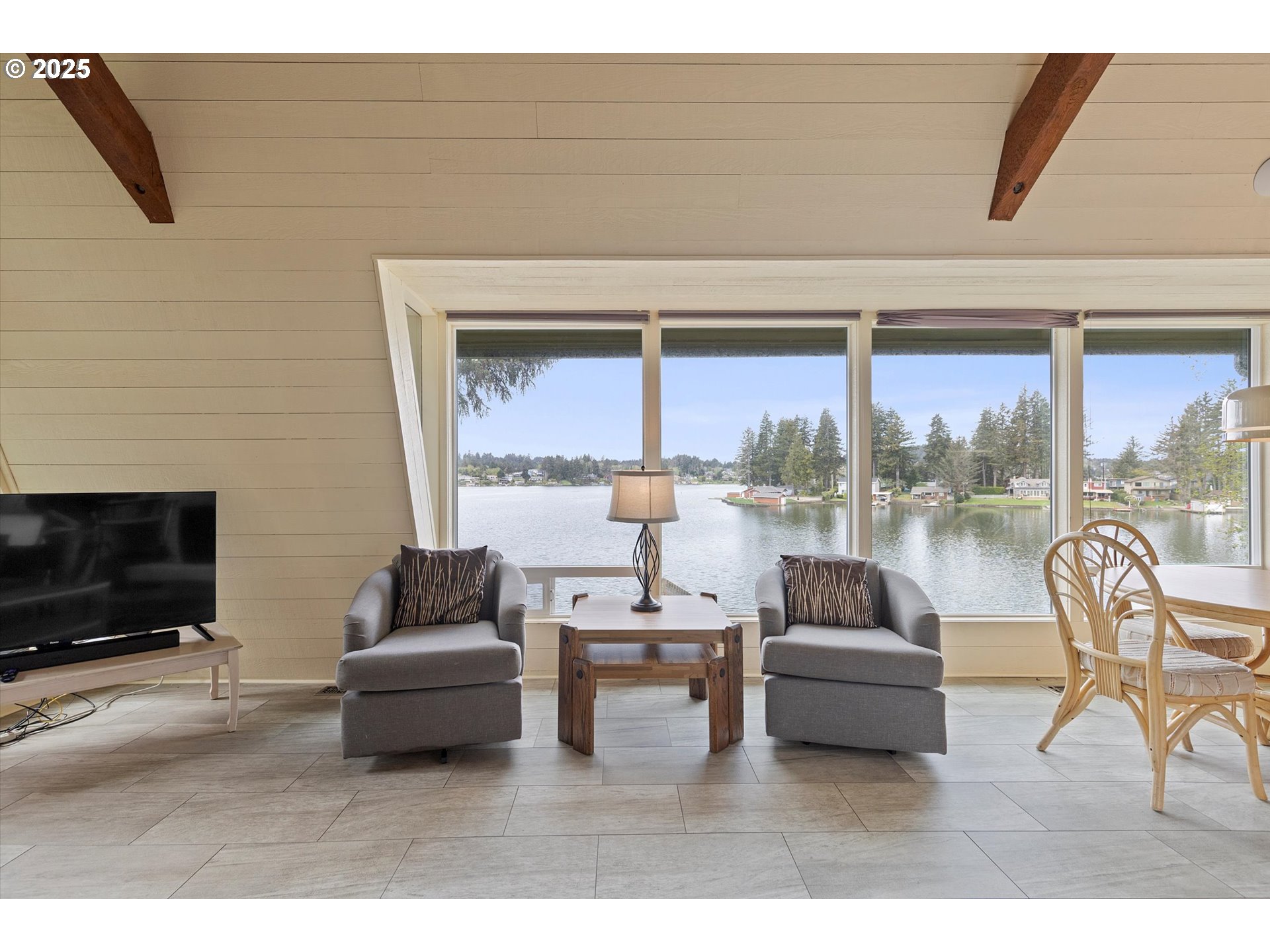 2871 Northeast East Devils Lake Road Otis, OR 97368 - Photo 16 of 48 a living room with furniture and a floor to ceiling window