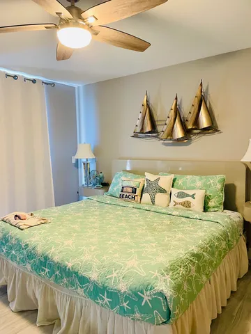 a bed with white sheets and pillows on the dresser