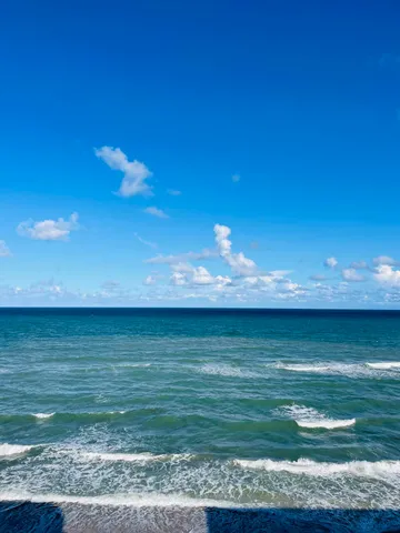 a view of a swimming pool with lawn chairs and a table