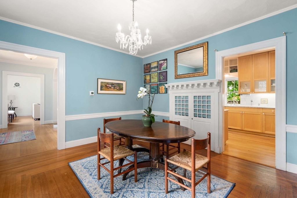 121 Bishopsgate Road Newton, MA 02459 - Photo 7 of 34 a dining room with wooden floor a chandelier a wooden table and chairs