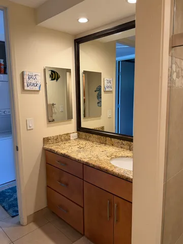 a bathroom with a granite countertop sink and mirror
