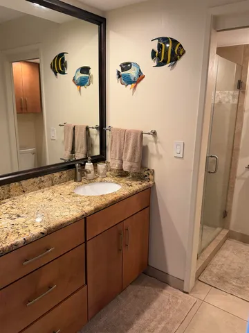 a bathroom with a granite countertop shower and a toilet
