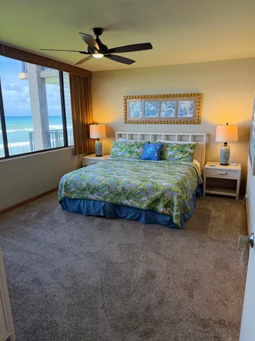 a spacious bedroom with a bed and a chandelier