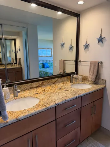 a bathroom with a granite countertop sink and a mirror