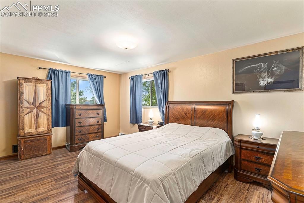 2905 Lauppe Road Yoder, CO 80864 - Photo 6 of 34 a bedroom with a large bed and wooden floor