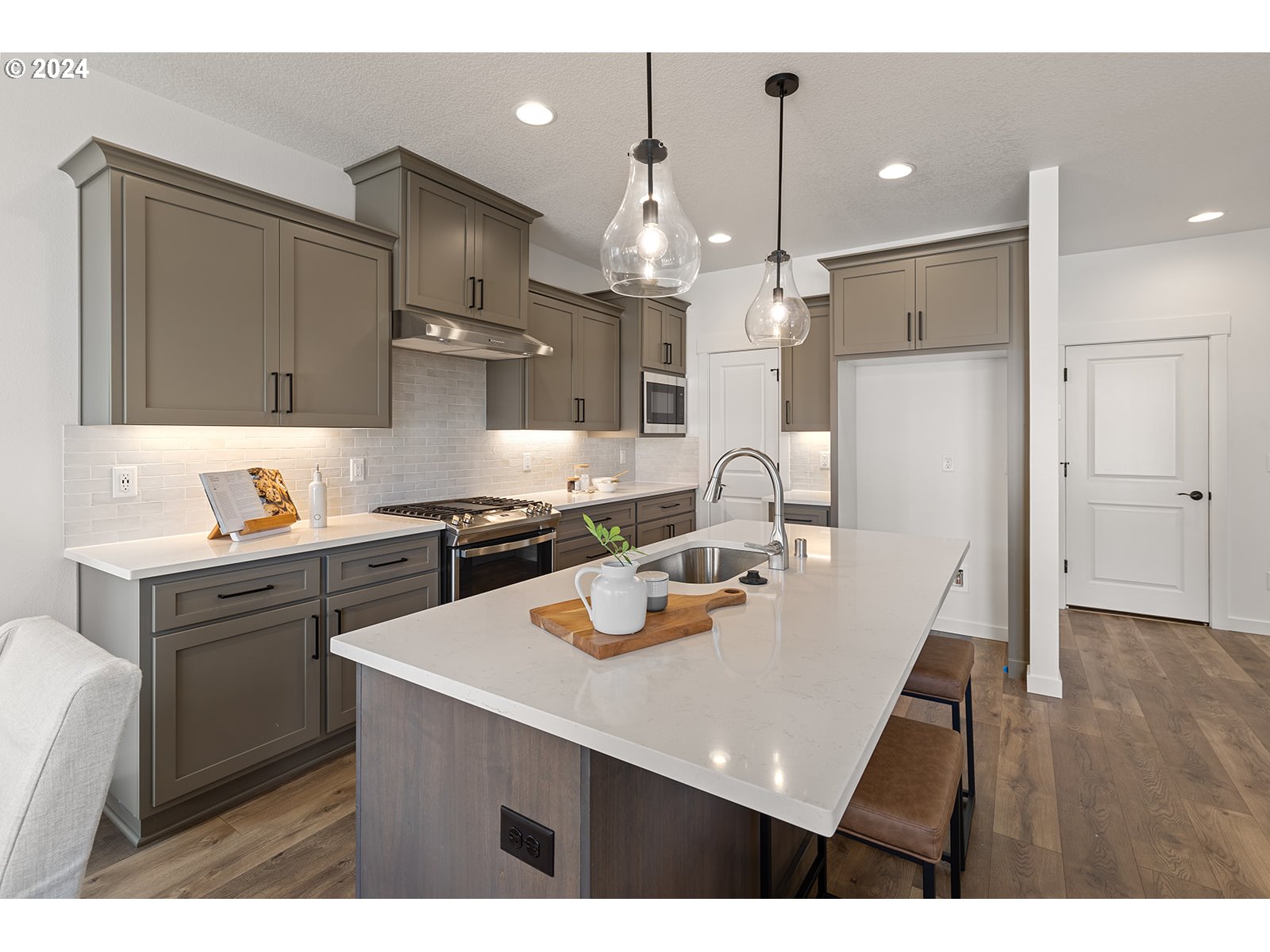 918 Northwest 178th Street Ridgefield, WA 98642 - Photo 16 of 47 a kitchen with a refrigerator a sink dishwasher with a dining table and chairs