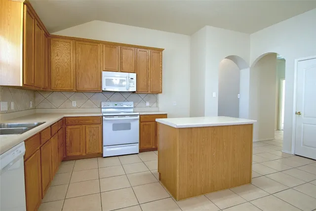 a kitchen with stainless steel appliances granite countertop a stove a sink a microwave and cabinets