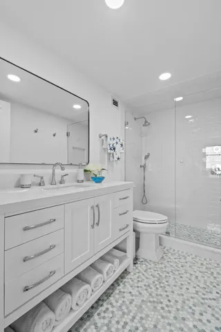 a spacious bathroom with a toilet sink and mirror
