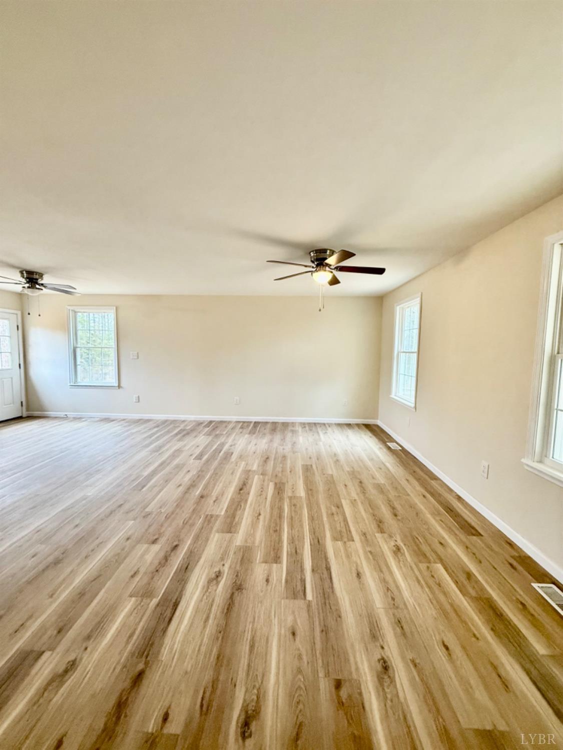 4103 Hog Wallow Road Nathalie, VA 24577 - Photo 3 of 20 an empty room with wooden floor cabinet and windows