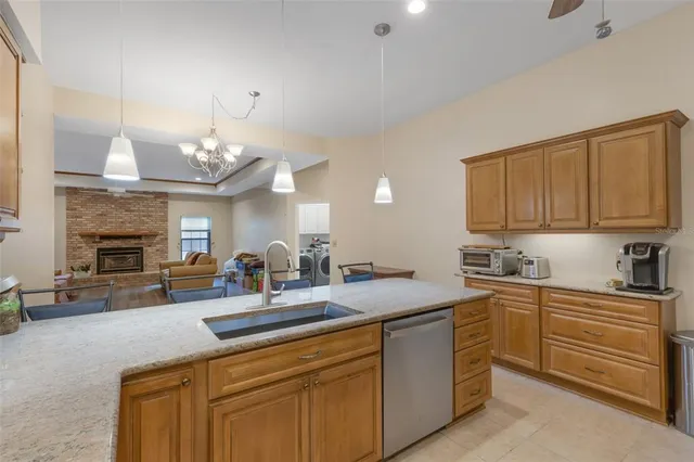 a kitchen with cabinets a sink and dishwasher a fireplace with wooden floor