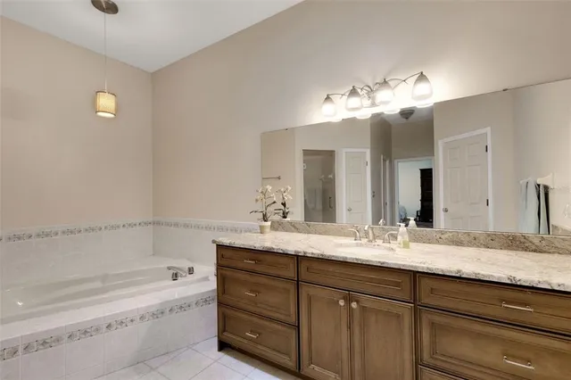 a bathroom with a granite countertop sink mirror and bathtub