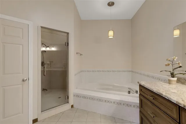 a spacious bathroom with a granite countertop tub sink and shower