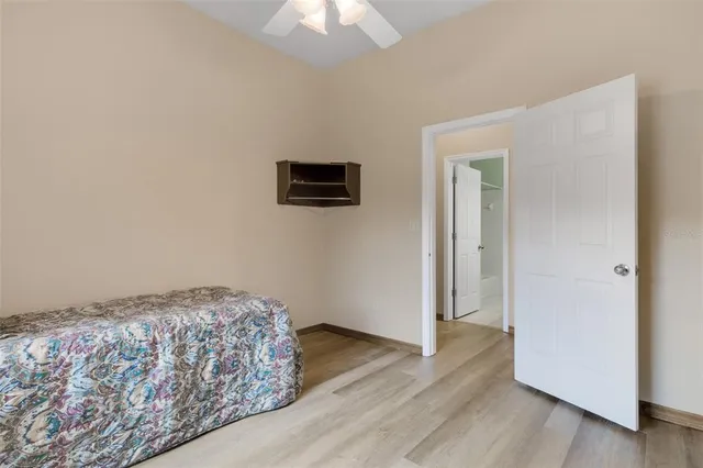 a bedroom with a bed and a chandelier fan