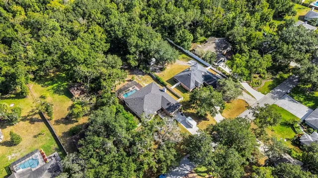 an aerial view of a house with a yard and swimming pool