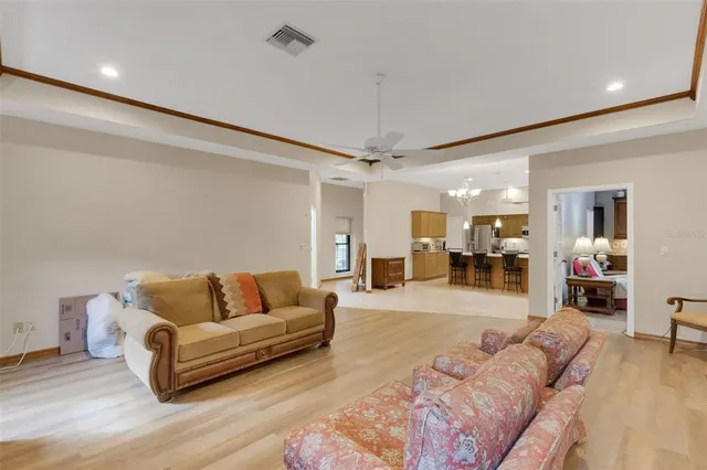 a living room with furniture and a large mirror with wooden floor