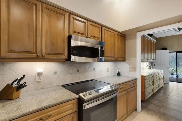 a kitchen with stainless steel appliances granite countertop a sink stove and microwave