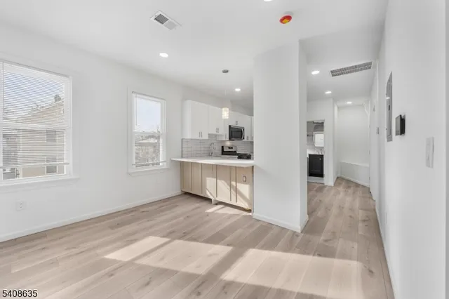 a view of kitchen with kitchen island white cabinets and refrigerator