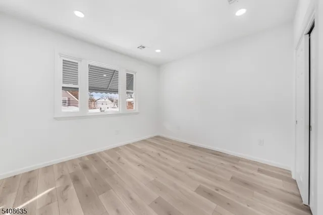 an empty room with wooden floor and window