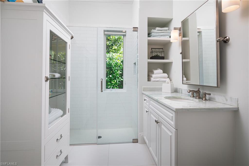 485 Wedge Drive Naples, FL 34103 - Photo 13 of 25 a bathroom with a double vanity sink a mirror and a shower